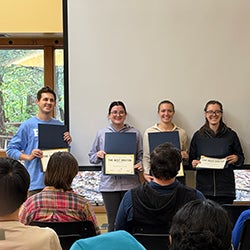 Four poster presentation award winners hold their awards at the Pharmacology 2025 research retreat.