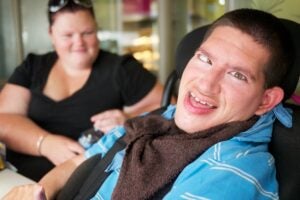 Smiling young man with a woman in the background