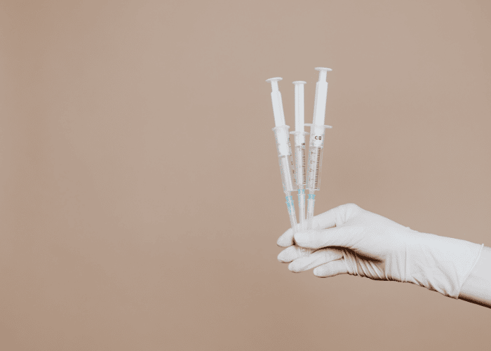A hand holding sharps